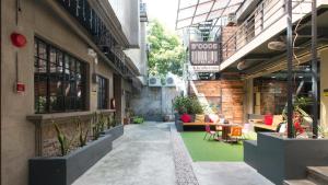 a courtyard of a building with tables and chairs at RedDoorz Plus @ Taft North Mandurriao in Iloilo City