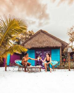 un groupe de trois personnes assises sur la plage dans l'établissement Bamboo Jam, à Koh Rong Sanloem