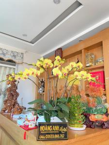 ein Regal mit Blumen und anderen Gegenständen darauf in der Unterkunft Hoàng Anh hotel in Ðưc Trọng