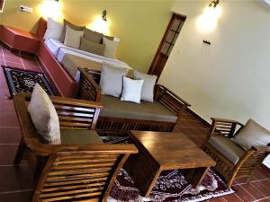 Zimmer mit einem Bett, einem Sofa und Stühlen in der Unterkunft Mandaram villas in Mararikulam