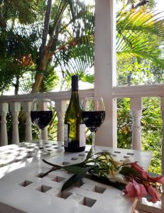 Una botella de vino y dos copas en una mesa. en Arcadia House, en Byron Bay