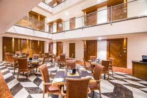 a restaurant with tables and chairs in a room at Zion - A Luxurious Hotel in Bangalore