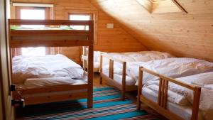 a room with three bunk beds in a cabin at Pension Kamifuji in Semi