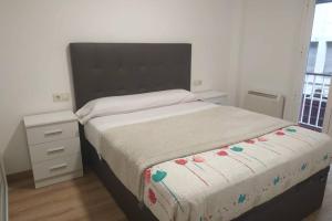 a bedroom with a large bed and a night stand at nuevo centrico y 15 min cerca de aguas termales in Ourense