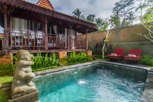 a swimming pool in front of a house at Tirta Jenar Villas in Tegalalang