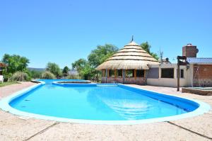 a large swimming pool with a gazebo at Pachanavira Cabañas & Suites in Nono
