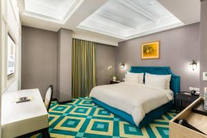 ジャカルタにあるHotel Des Indes Mentengのベッドとデスクが備わるホテルルームです。