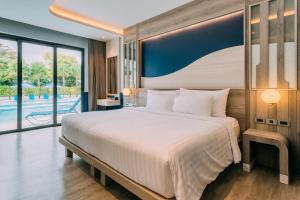 a bedroom with a large bed and a pool at Seabed Grand Hotel Phuket in Phuket