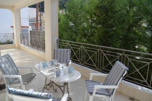 a patio with a table and chairs on a balcony at Blue Ark Aigeira Flat & Studio in Aíyira