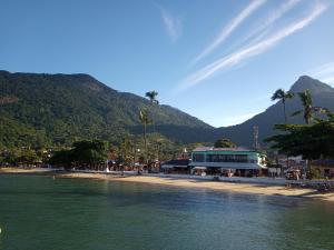a beach with a building next to the water at Nosso Pedacinho in Abraão
