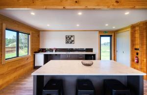 a kitchen with a large island in the middle of a room at Deerbrooke Kaikōura Chalets - Chalet 1 in Kaikoura