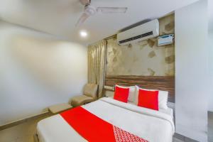 een hotelkamer met een bed met rode kussens bij Serenity Inn in Chennai