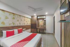 een slaapkamer met een groot bed en een televisie bij Serenity Inn in Chennai