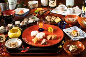 uma mesa de madeira com pratos de comida em Temple Hotel 正暦寺 em Ayabe