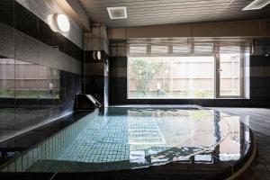 a swimming pool with a glass floor in a building at Kanazawa Central Hotel Annex in Kanazawa