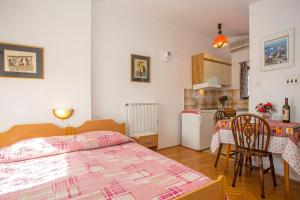 1 dormitorio con 1 cama y cocina con mesa en Apartments Jaksa, en Pula