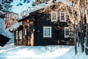 una cabaña de madera en la nieve con nieve en Bardøla Fjelltun, en Geilo