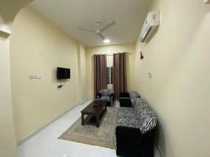 a living room with a couch and a tv at RED Tag Salalah in Salalah