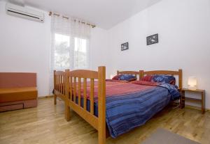 a bedroom with a wooden bed and a large window at Apartment Pavlovic in Rovinj