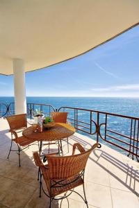 una mesa y sillas en un balcón con vistas al océano en Yacht Club Yalta, en Yalta