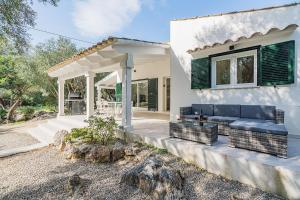 Casa blanca con sofá y patio en Can Romani, en Pollensa