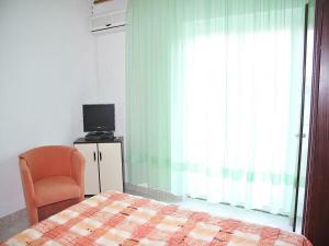 1 dormitorio con 1 cama, 1 silla y 1 ventana en Apartments Lovran en Lovran