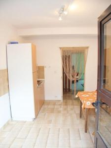 ein Wohnzimmer mit einem Tisch und einer Küche in der Unterkunft Apartments Lovran in Lovran