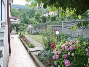 d'un jardin avec des fleurs colorées et une clôture. dans l'établissement Apartments Lovran, à Lovran