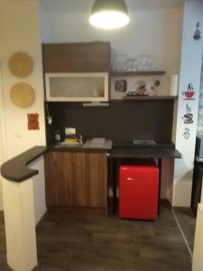 a small kitchen with a black counter and a red stool at Stylisches Innenstadtappartement in Graz