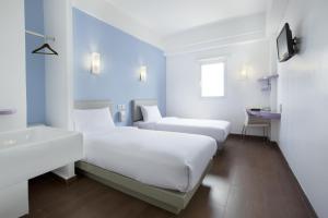a white room with two beds and a sink at Amaris Hotel Bandara Soekarno Hatta in Tangerang