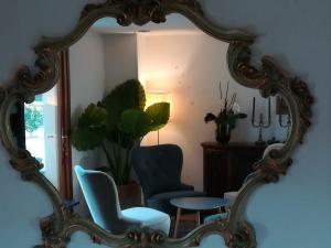 a mirror in a room with two chairs and a table at Hotel Villaguarda Landscape Experience in Follina