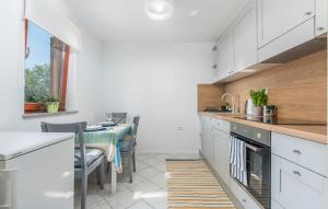una cocina con armarios blancos y una mesa con sillas. en Apartment Nino, en Kanfanar