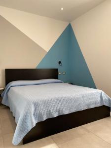 Schlafzimmer mit einem Bett mit blauem Akzent in der Unterkunft Azalea Appartamenti in Cannobio