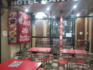 a dining room with red tables and chairs in a restaurant at Hotel Aarti Darshan in Haridwār
