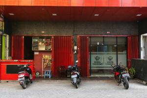 two motorcycles parked in front of a store at RedDoorz @ Hertasning Area 2 in Makassar
