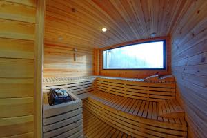 a wooden sauna with benches and a window at AQUARIUS BOUTIQUE HOTEL in Câmpulung Moldovenesc