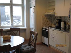 a kitchen with a table and a table and a window at Apartments Hotel Rivoli Jardin in Helsinki