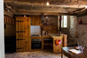a small kitchen with wooden cabinets and a table at Gite E'table Charlannes in Hautefage