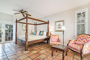 1 dormitorio con cama con dosel y silla en Grandview Gardens, en West Palm Beach