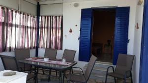 a dining room with a table and chairs and a blue door at Galazio Kyma in Agios Ioannis