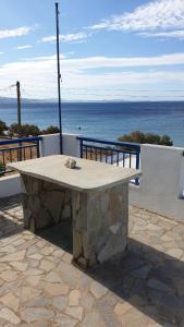 a stone table sitting on top of a building with the ocean at Galazio Kyma in Agios Ioannis