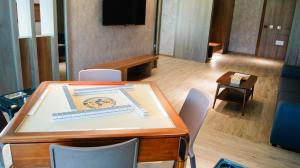 a room with a table and chairs and a television at Kuei Ti Wan Hotel in Checheng