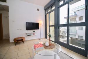 a living room with a tv and a glass table at Chic apartment! city center in Tel Aviv