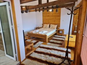 - une chambre avec un lit dans une pièce dotée de murs en bois dans l'établissement Mamin Kolio, à Bansko