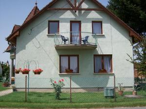 a house with a balcony on the side of it at Borostyán Vendégház in Balatonkeresztúr