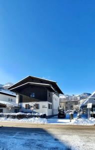 a house with a car parked in the snow at Haus Pankratz in Kitzbühel