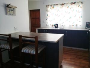 uma cozinha com mesa e cadeiras e uma janela em Gansbaai Self-Catering Apartment em Gansbaai