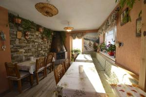 a dining room with a table and chairs and a brick wall at Garni La Genziana in Temù
