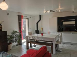uma sala de estar com uma mesa branca e uma cozinha em L'OUSTAOU em Signes