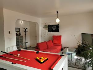 uma sala de estar com uma mesa de bilhar vermelha em L'OUSTAOU em Signes